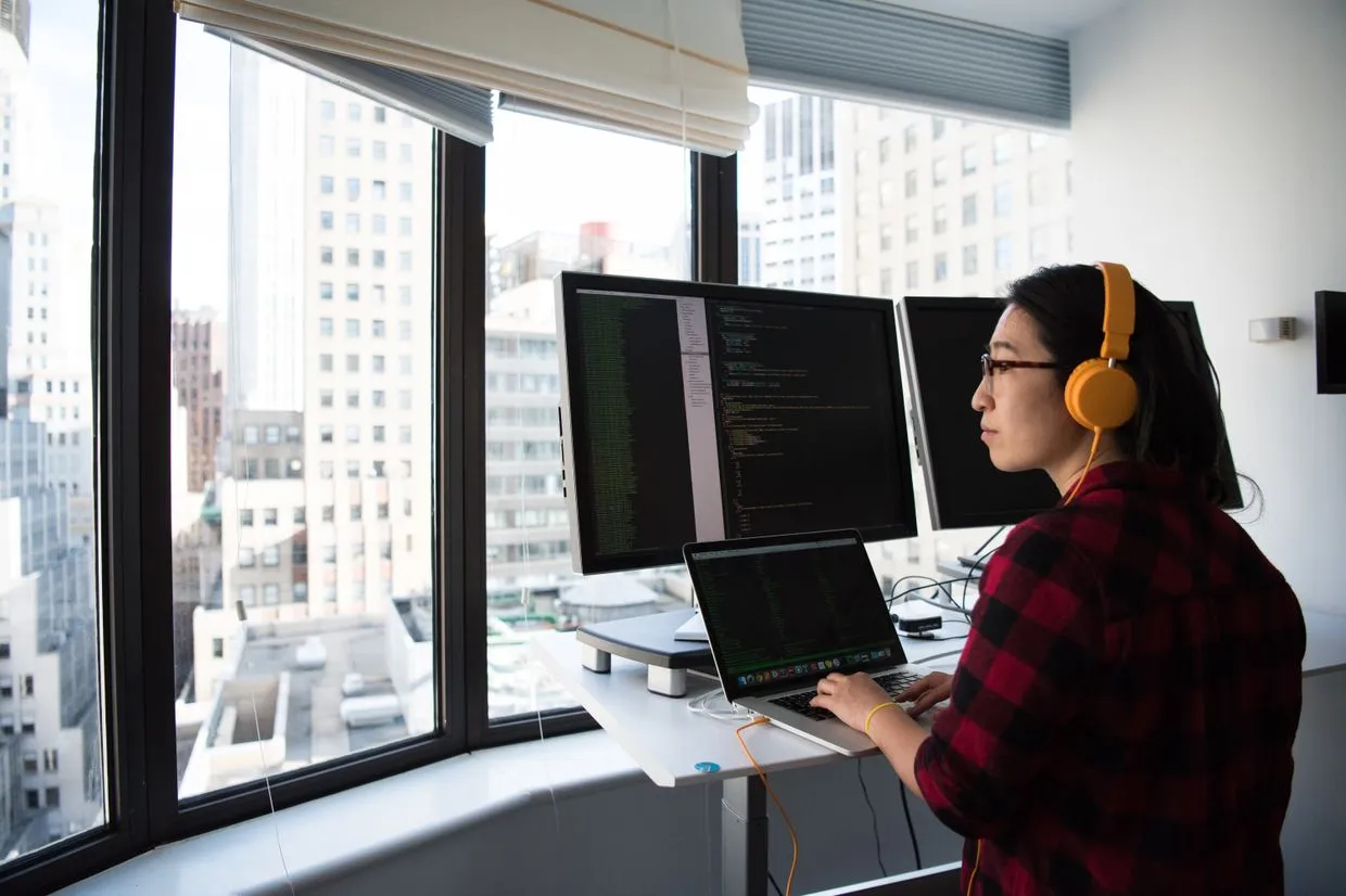 JavaScript Development — Developer hand-building a website across two screens of code